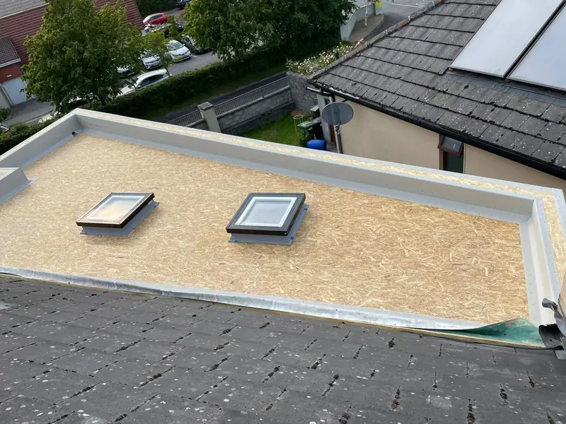 Flat roof OSB deck prepared with trims and rooflight upstands before the GRP layer