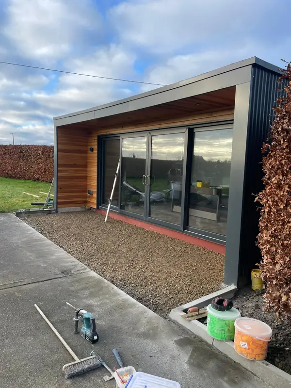 Insulated garden room with western red cedar cladding and full-height sliding doors