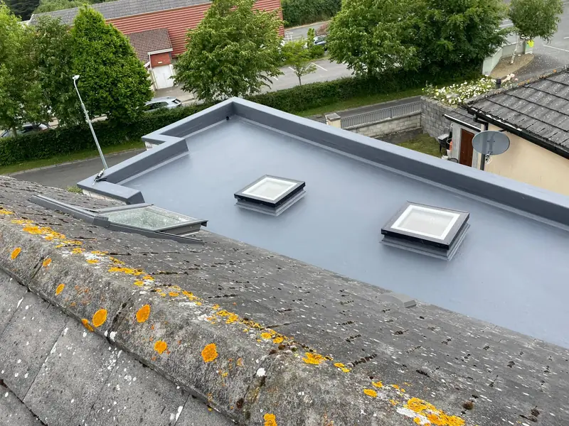 Completed grey GRP fibreglass flat roof with two flat rooflights installed