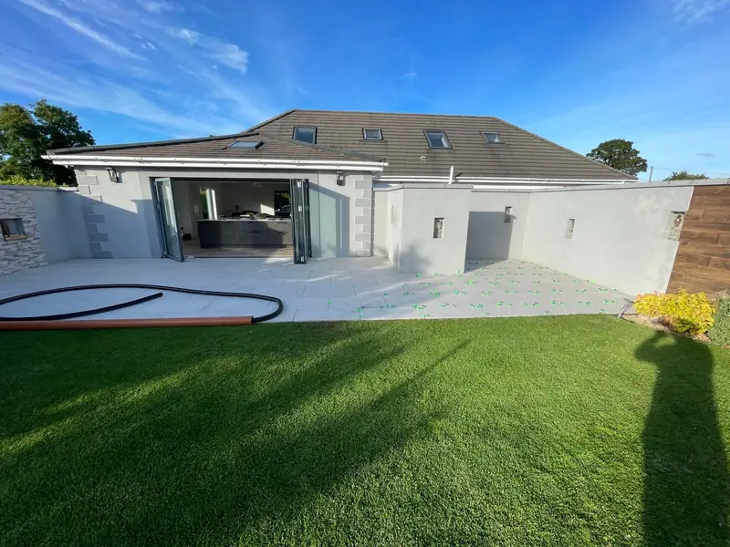 Completed rear extension with anthracite bifold doors opening onto a porcelain patio and lawn